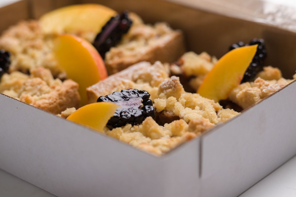 A close-up of baked fruit crumble with a golden oat streusel topping.