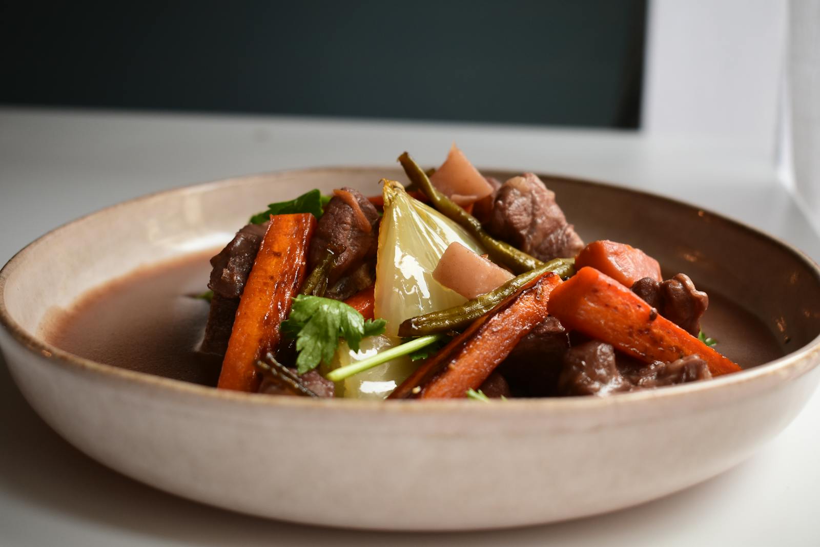 Bowl of hearty beef and barley soup with root vegetables