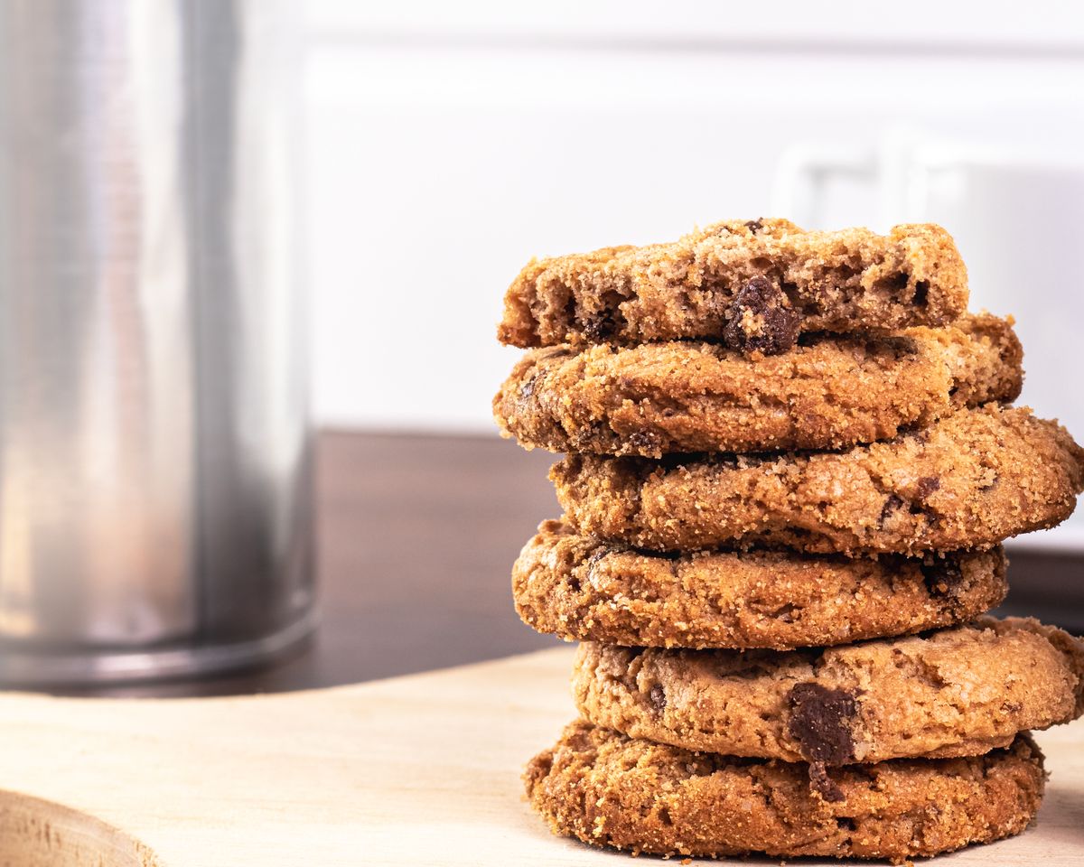A stack of homemade chocolate chip cookies with a bite taken from the top cookie.