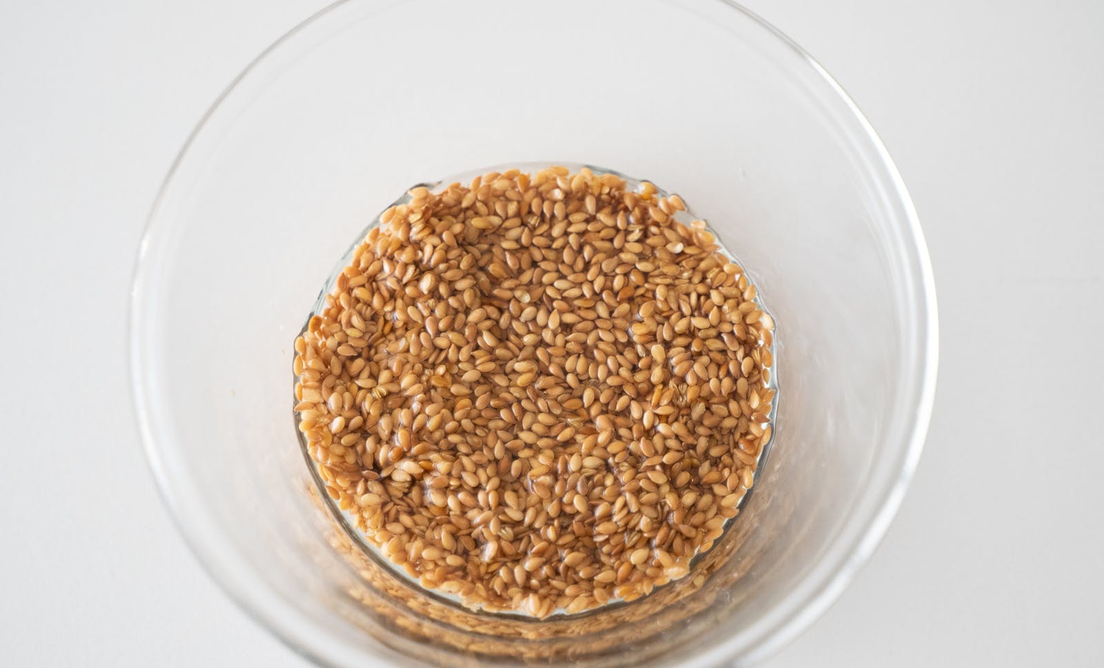 Wheat berries soaked in a glass bowl, viewed from above