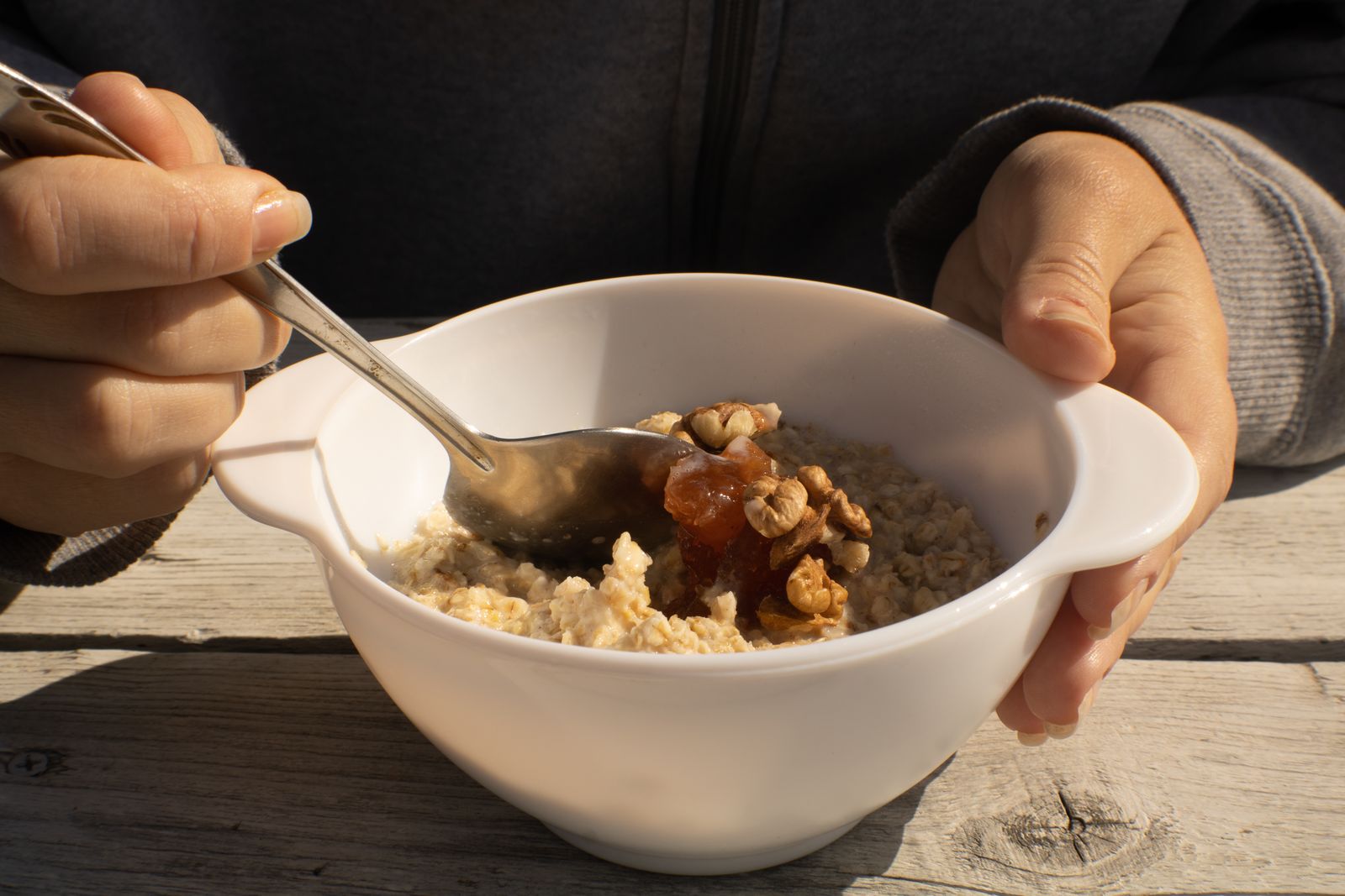 A bowl of cooked steel cut oats topped with walnuts and honey
