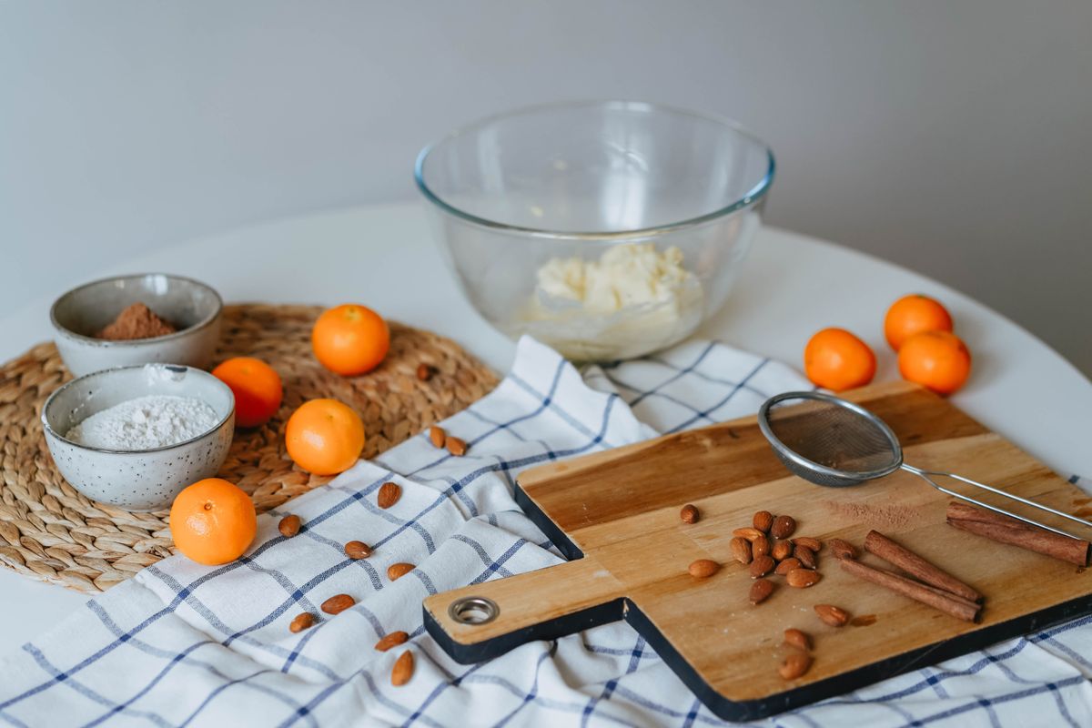 A baking setup with almonds, flour, and cinnamon on a kitchen table, the ingredients behind homemade almond flour baking.
