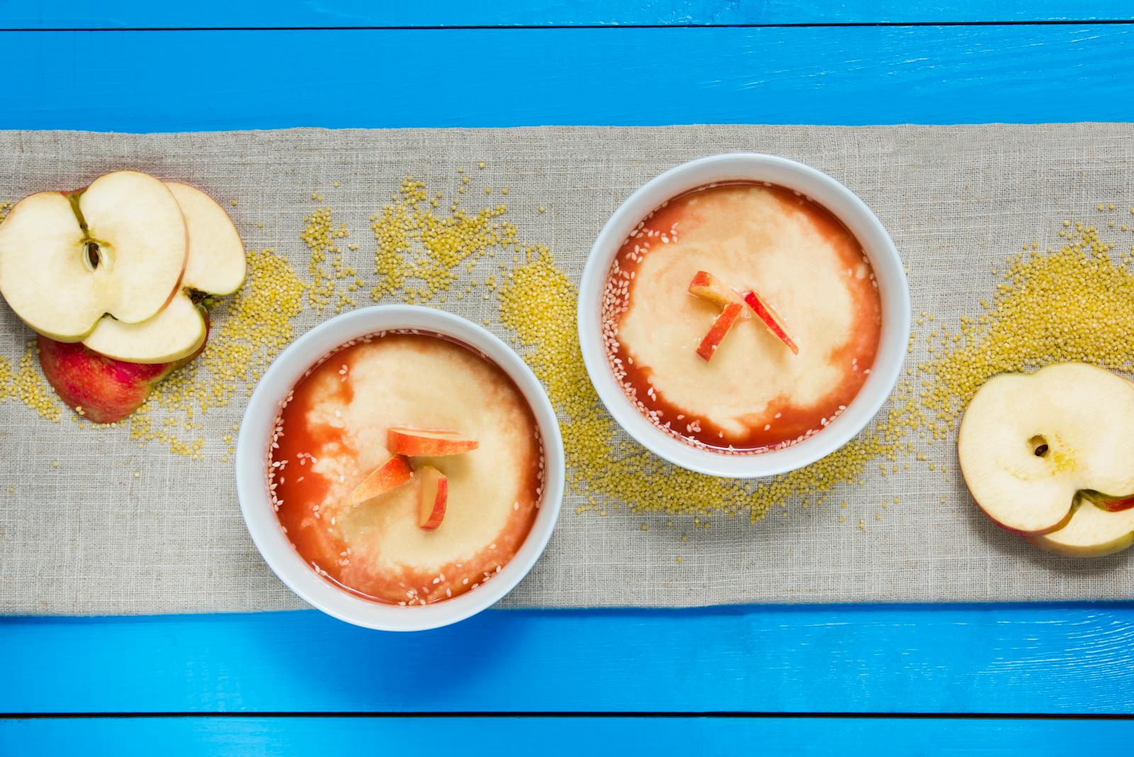 A top-down bowl of cooked millet porridge topped with sliced pear, one of the breakfast preparations covered in this recipe roundup.