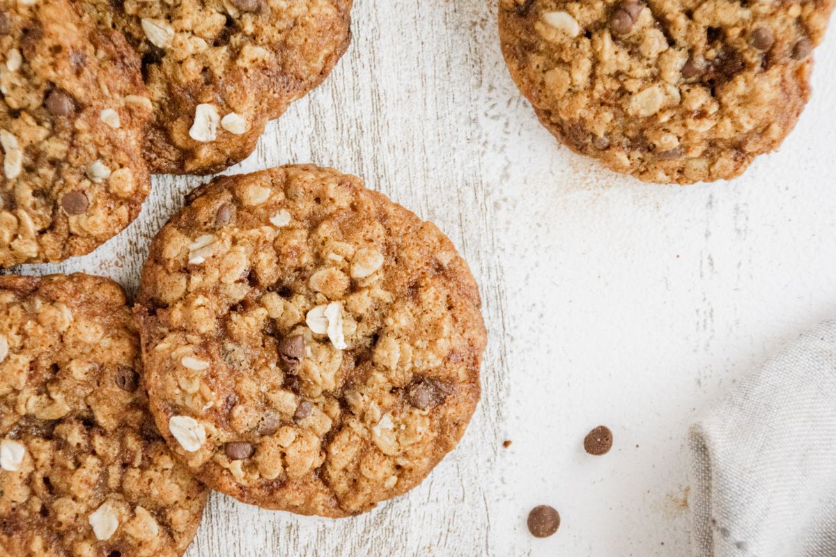 Close-up of homemade oatmeal chocolate chip cookies on a rustic wooden table.