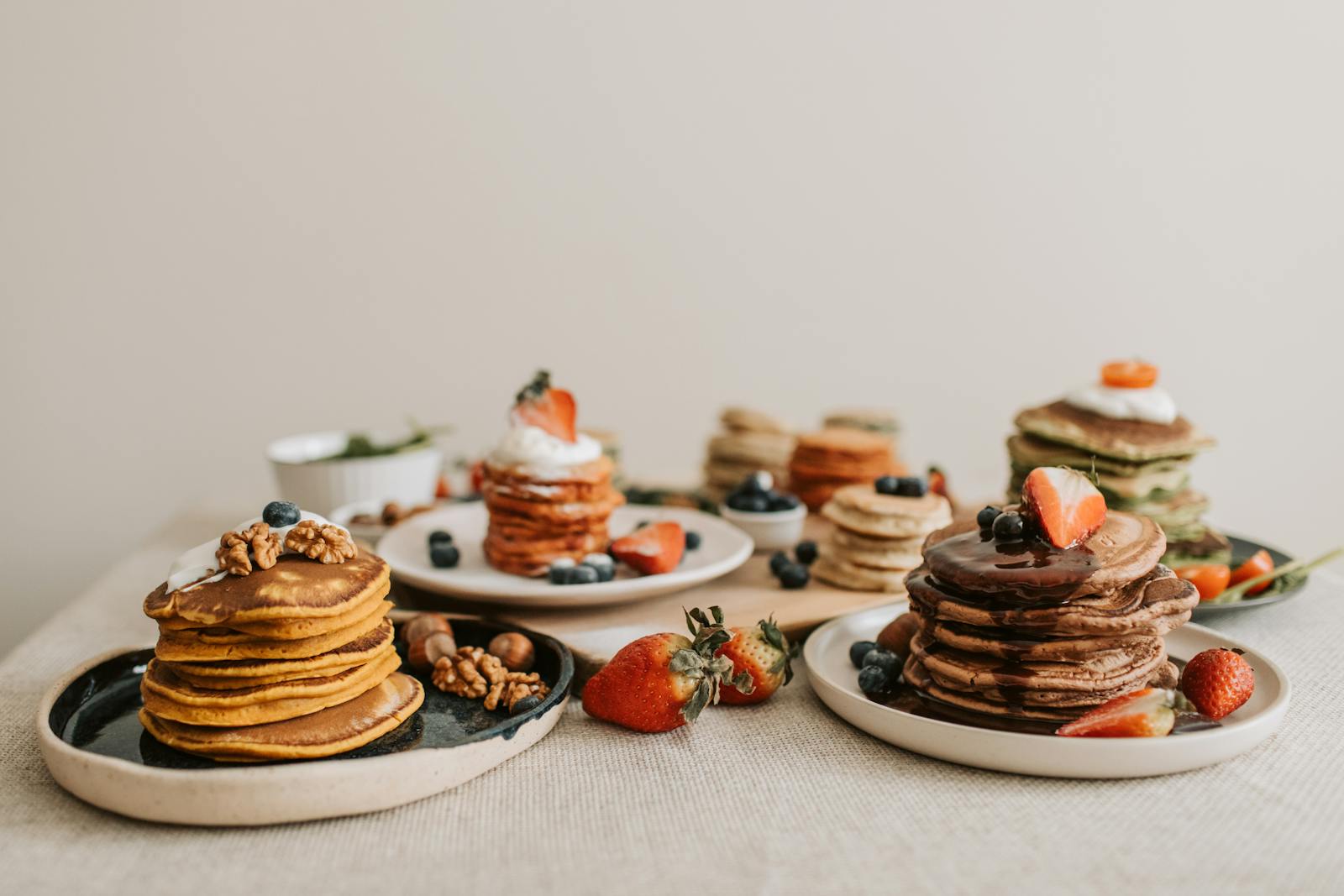 A plate of golden oat flour pancakes garnished with fresh berries and chopped nuts, the kind of breakfast you would find in a Highland croft kitchen.