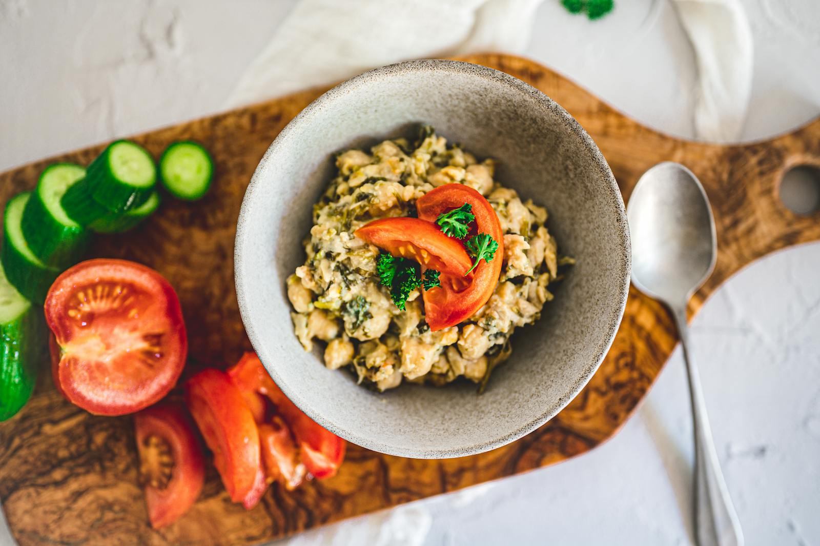 A top-down view of a chickpea and grain salad with fresh tomatoes and cucumbers, the bright assembly behind this quinoa chickpea salad recipe.