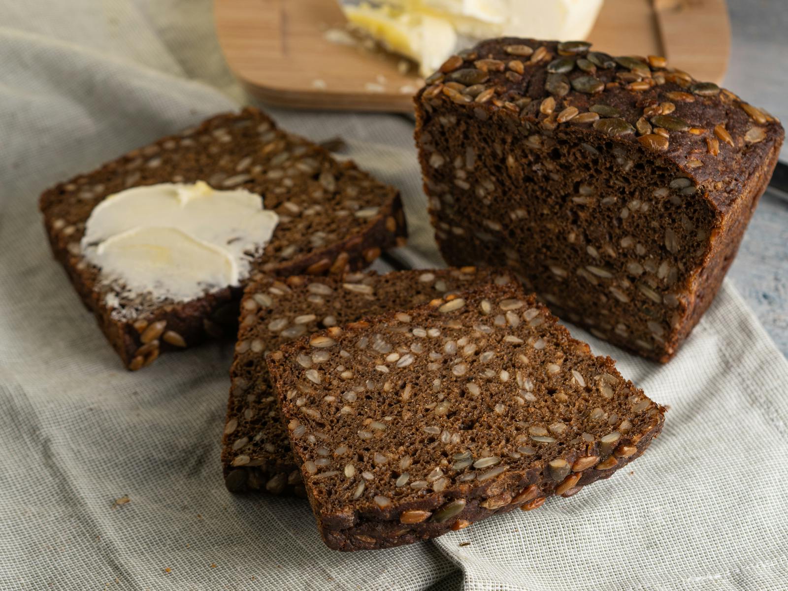 Sliced Danish-style dark rye bread (rugbrød) with butter, the classic Nordic loaf built on a foundation of whole rye flour.