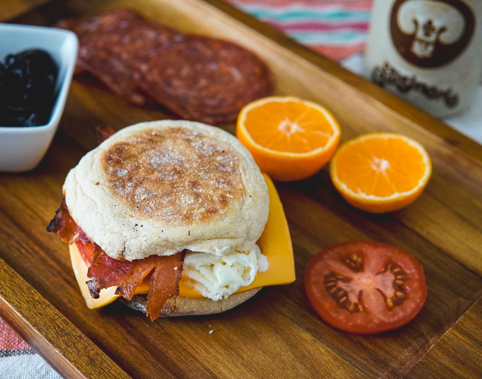 A breakfast sandwich with egg, bacon, and cheese on a split English muffin