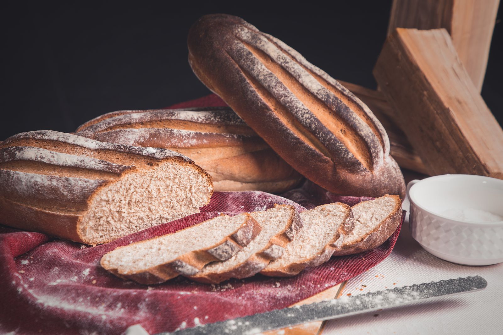 A sliced homemade heritage-wheat loaf on rustic cloth, the kind of bread this spelt recipe produces.