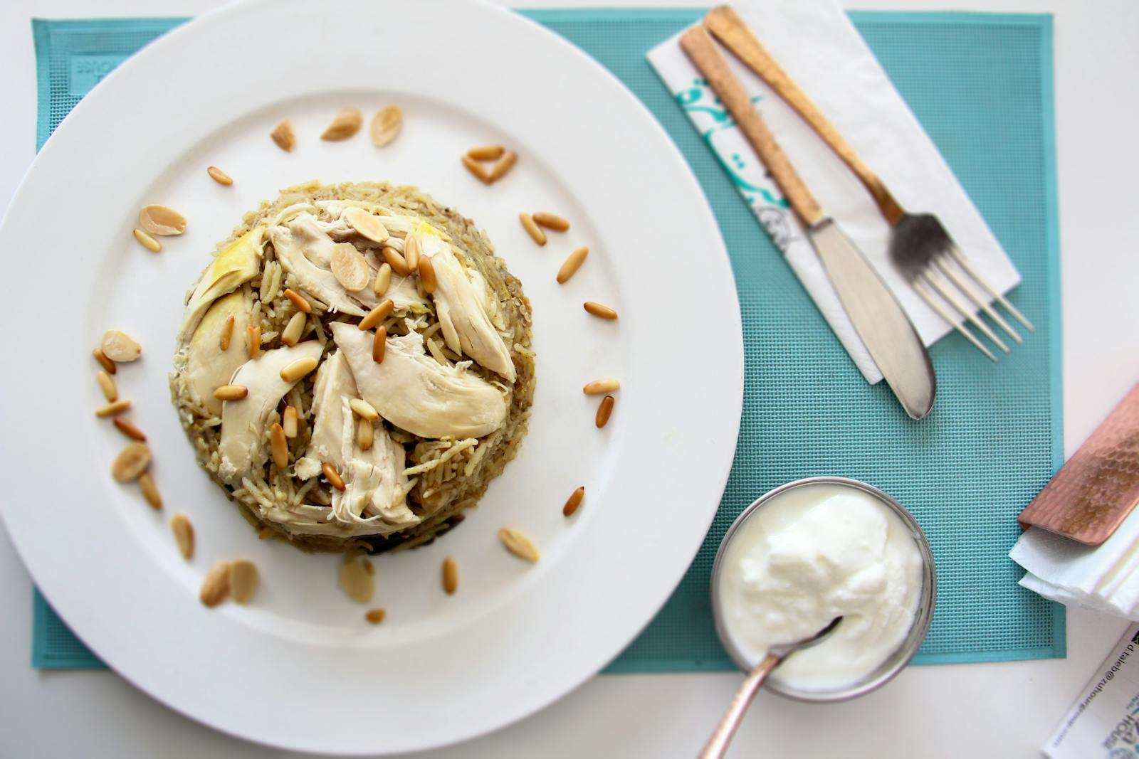 A Middle Eastern grain dish topped with pine nuts and yogurt, the kind of plate freekeh has anchored in Levantine kitchens for thousands of years.